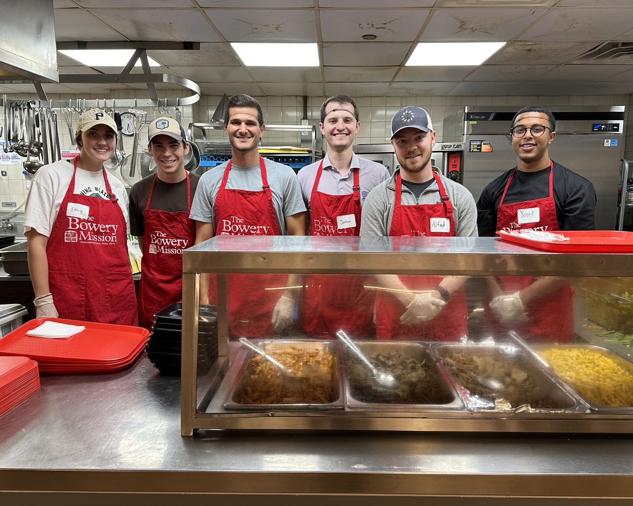 JFLCO team members volunteering in the kitchen during dinner service at The Bowery Mission.